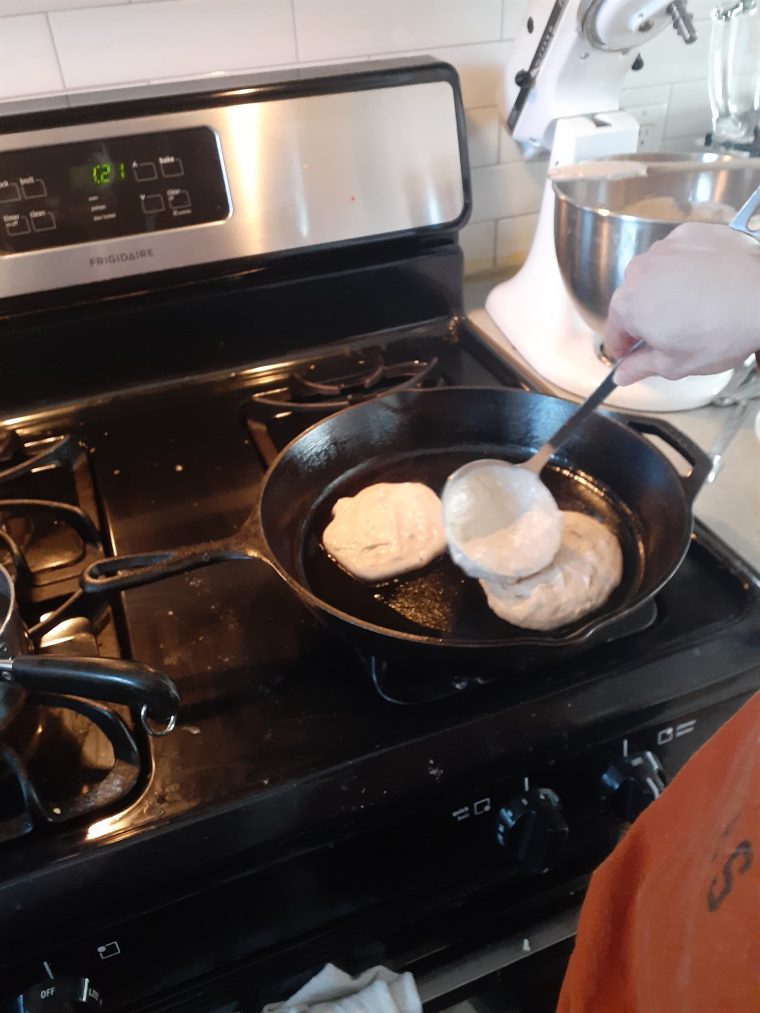 Spreading out whole wheat pancake batter in skillet
